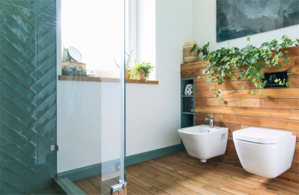 Bagno con parete e pavimento effetto legno vicino alla doccia