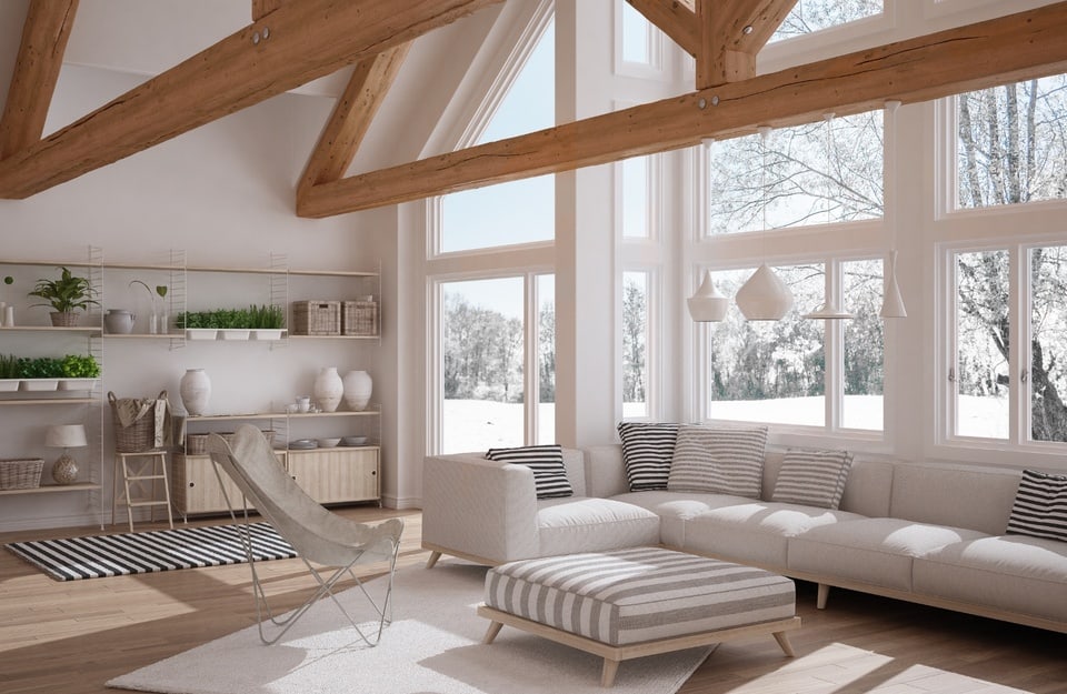 Ampio soggiorno con travi in legno, parquet chiaro e grandi finestre in inverno